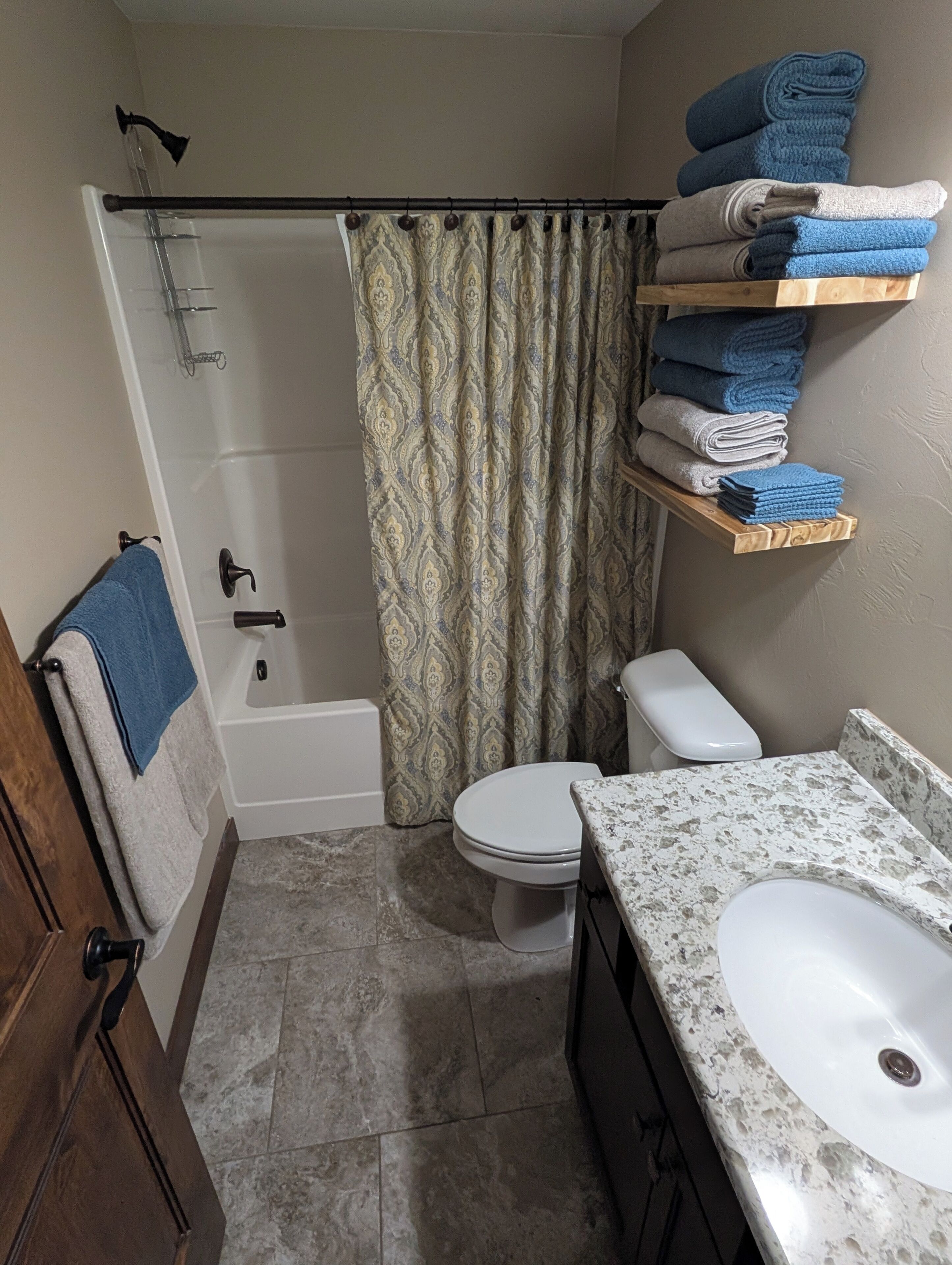 Une salle de bain avec une douche, des toilettes et un lavabo.