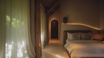 Un dormitorio con una cama, cortinas, cabecera de madera y una mesita de noche.