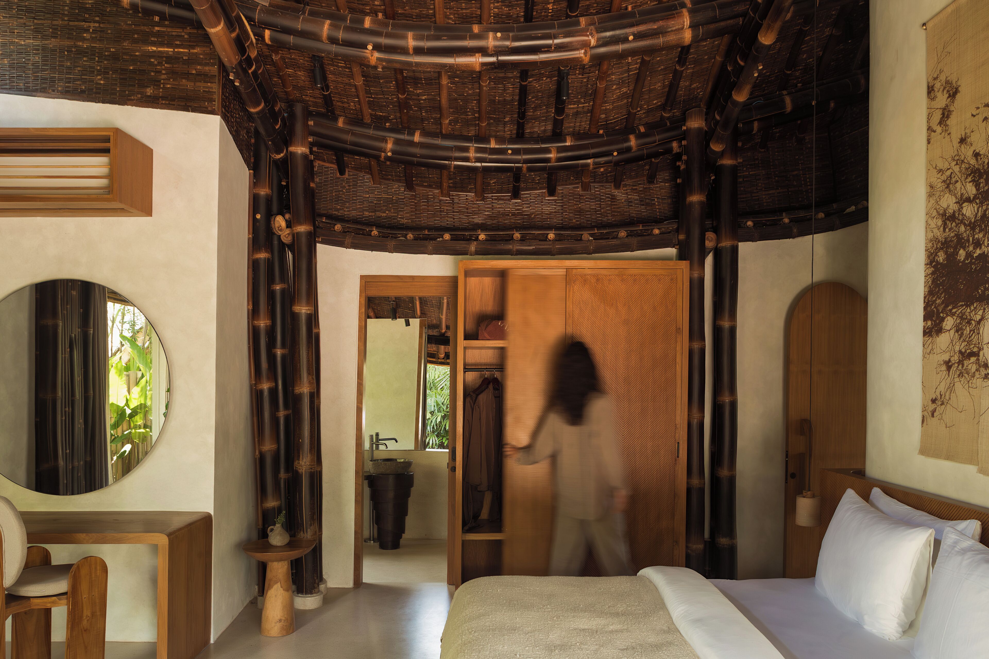 Une chambre à coucher avec un lit, un bureau, un miroir et une armoire.