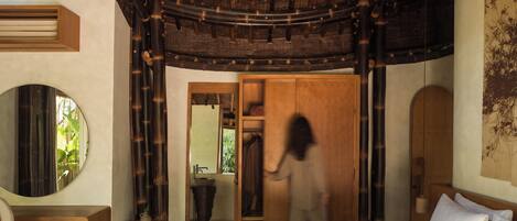 Une chambre à coucher avec un lit, un bureau, un miroir et une armoire.