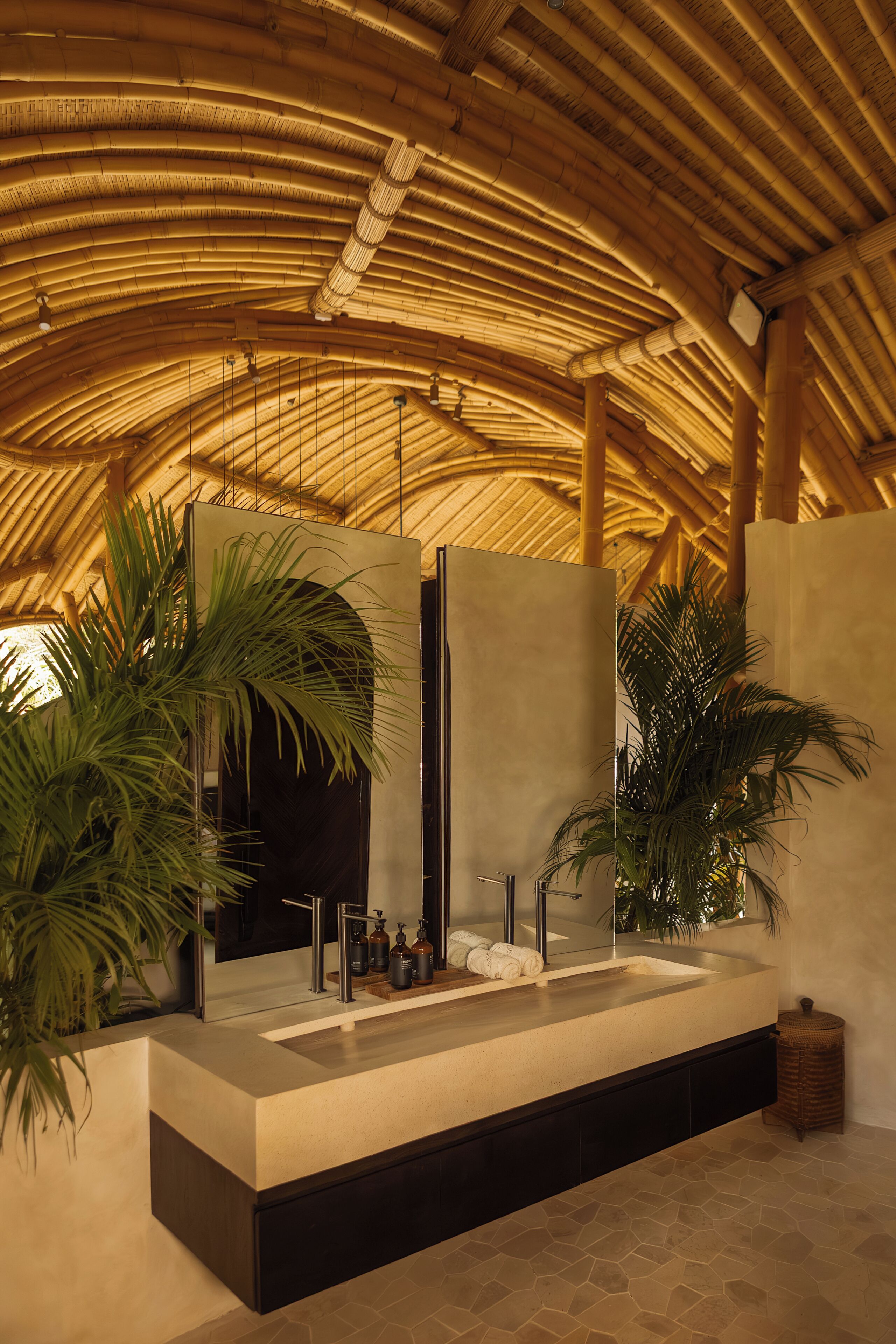 Une salle de bain moderne avec un plafond en bambou, un grand miroir et un lavabo intégré.