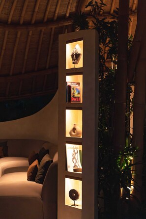 Un intérieur moderne avec un canapé, un luminaire vertical et une plante en bambou.