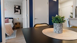 A room with a dark-colored table, a woven placemat, and a potted plant. - Modern 1BR Near Downtown | Walkable City Stay (Minneapolis)