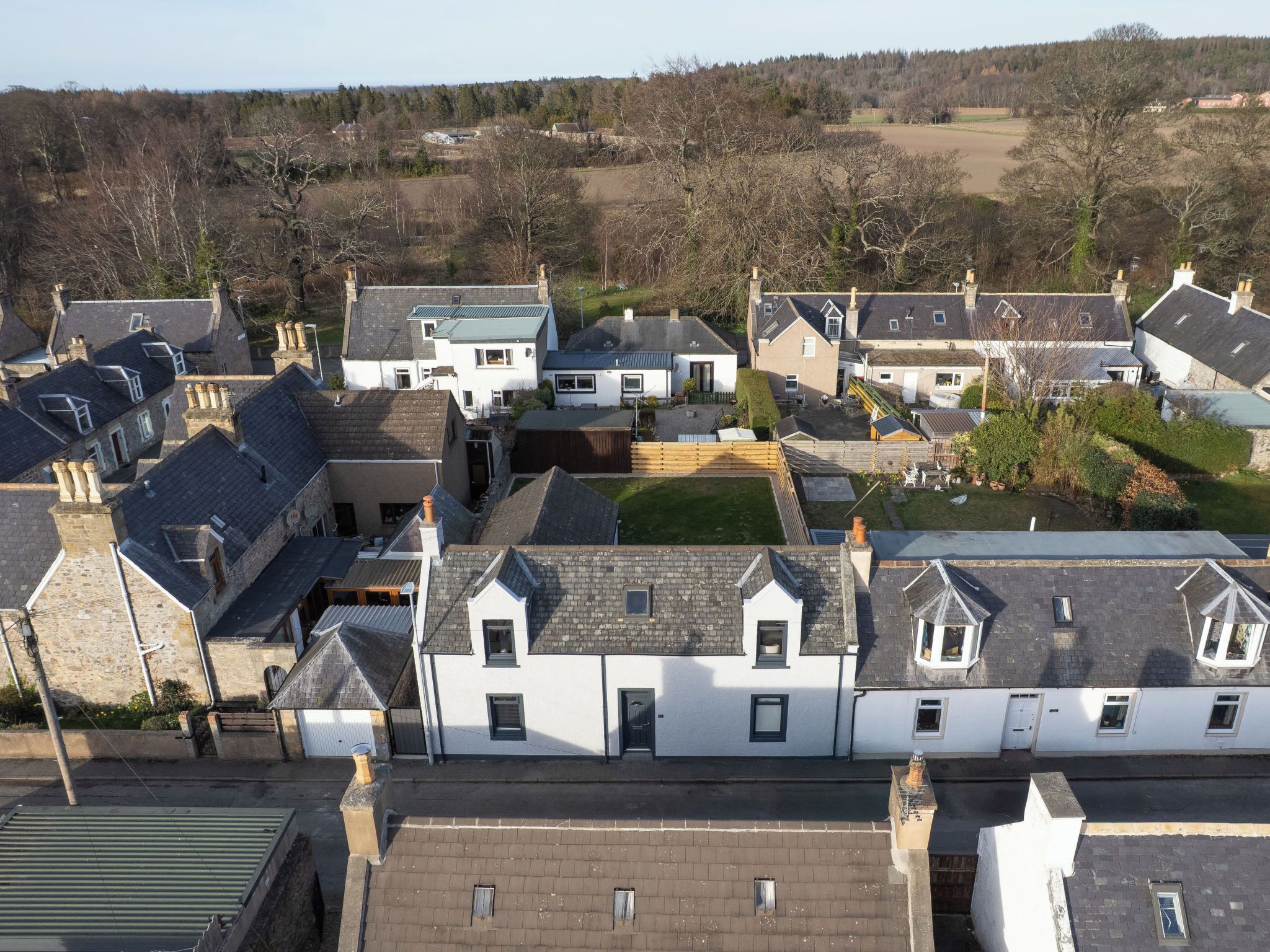 Een woonwijk met huizen met puntige daken, schoorstenen en gevels van baksteen en natuursteen.