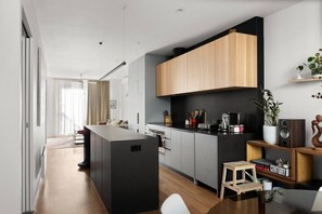 Eine moderne Küche mit einer zentralen Kochinsel, Holzschränken und einer schwarzen Arbeitsplatte.