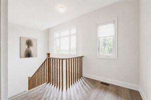Eine Treppe mit Holzbalkonen führt zu einer Empore mit zwei Fenstern.