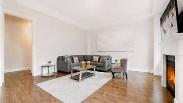 Ein modernes Wohnzimmer mit Kamin, Ecksofa, Couchtisch und Teppich.