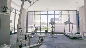 A gym with cardio machines, weight equipment, and a bench. - Elevated CBD Escape Level 6 Views & Resort Facilities (Townsville)