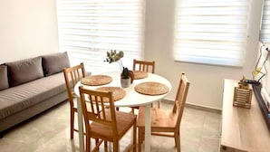 A dining area with a round table, wooden chairs, and a sofa. - Business & Leisure Premium Apartment | Fast Wi-Fi & Prime Location (Villavicencio)