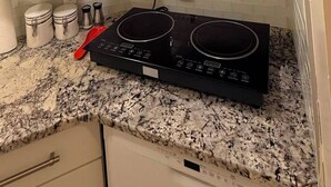A kitchen with a microwave, stove, and white cabinets. - Gateway to Banff | Cozy 2BR Sleeps 6 | NW Calgary (Calgary)