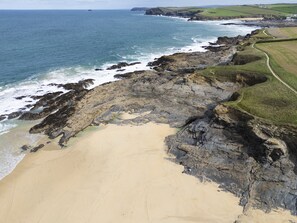 A coastal landscape with a sandy beach, rocky cliffs, and a winding path. - Treth Nook - Dog friendly, 100m from beach, Parking (Harlyn Bay)