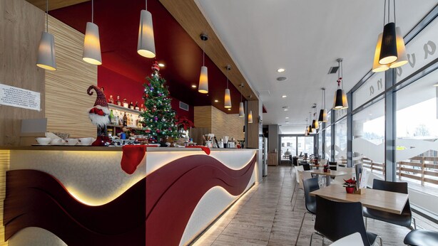Eine moderne Bar mit Weihnachtsbaum, Holzelementen und Pendelleuchten.