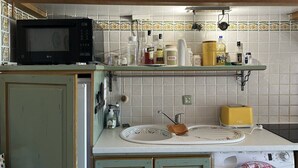 A kitchen with a microwave, sink, and various kitchen items on the counter. - Renovated mas with beautiful sea views, accommodating up to 4 guests. (SAINTE MAXIME)