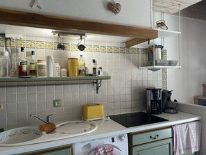 A kitchen with a sink, a toaster, a coffee maker, and various kitchen items on the counter. - Renovated mas with beautiful sea views, accommodating up to 4 guests. (SAINTE MAXIME)
