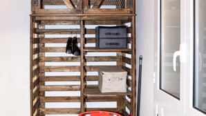 A wooden crate storage unit with shelves, a table, and red chairs. - Trastevere Secret Loft (ROMA)