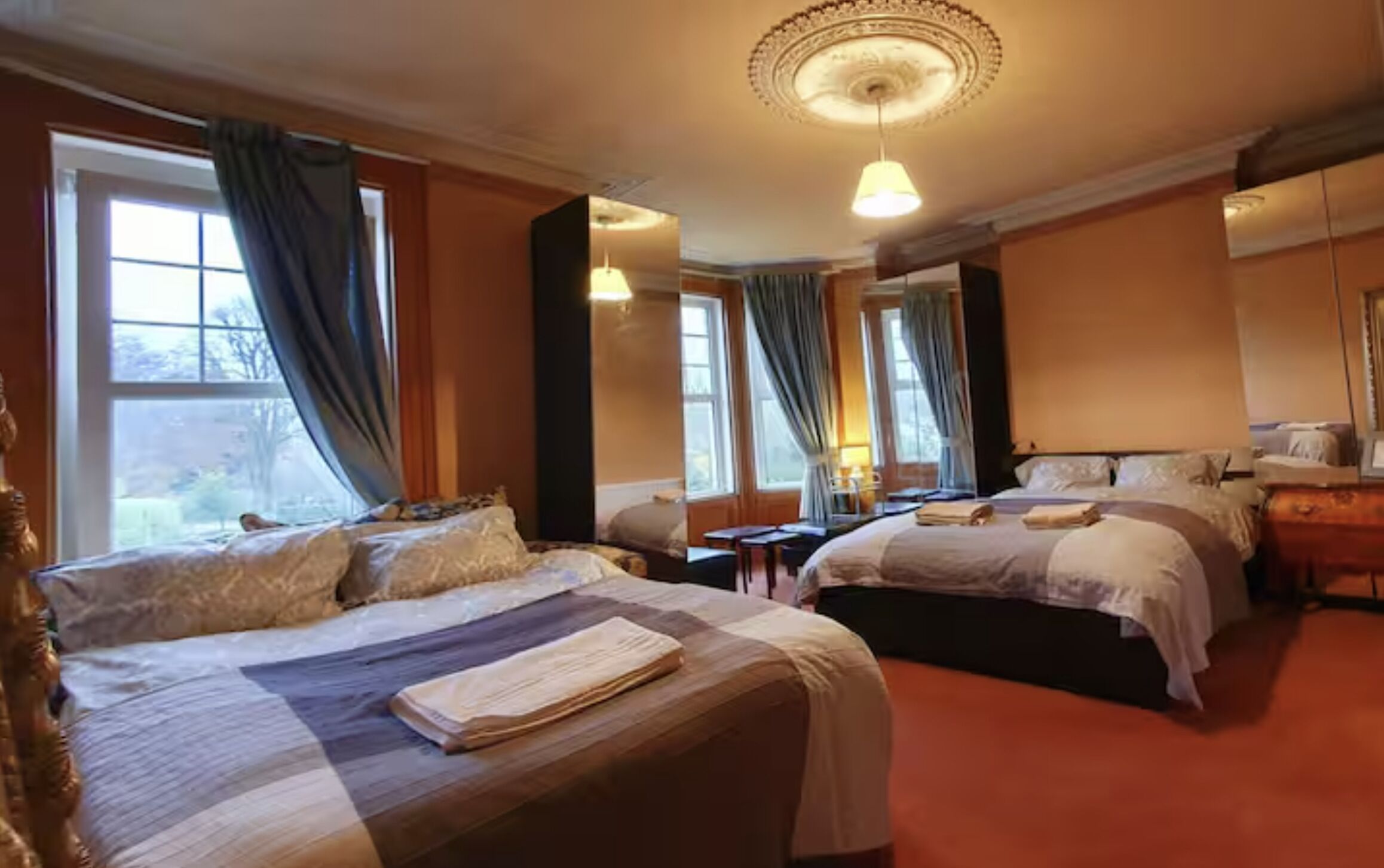 A hotel room with two beds, a desk, and a chair.