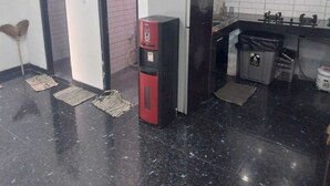 Una cocina compacta con un refrigerador, un lavamanos y un bote de basura.
