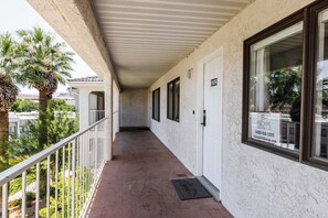 A corridor with a white exterior, a metal railing, and a door labeled "1425".