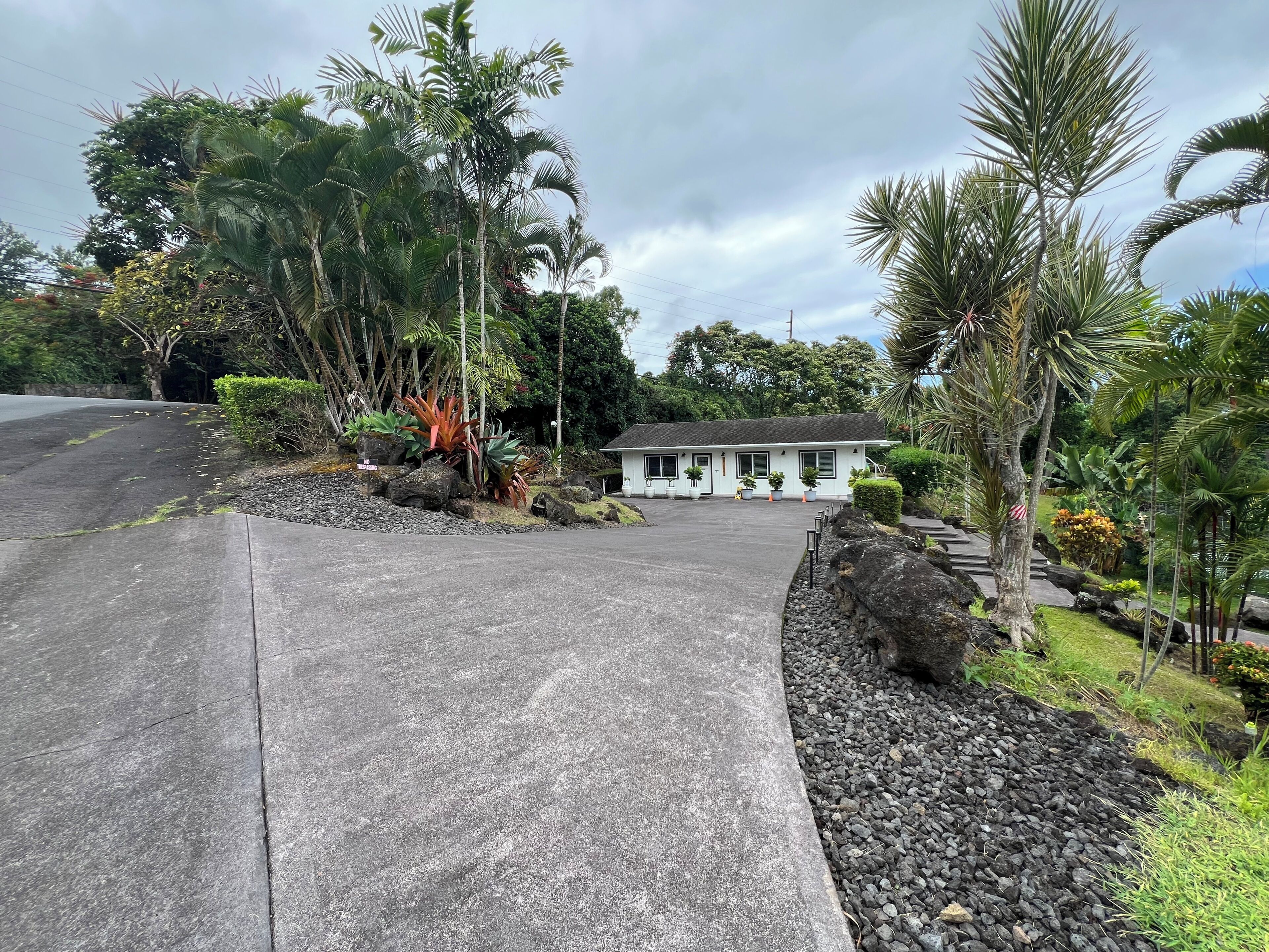 A two-story building with a paved driveway leading to a gated entrance.