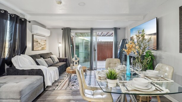 A modern living room with a sofa, coffee table, and dining area set up for a meal.