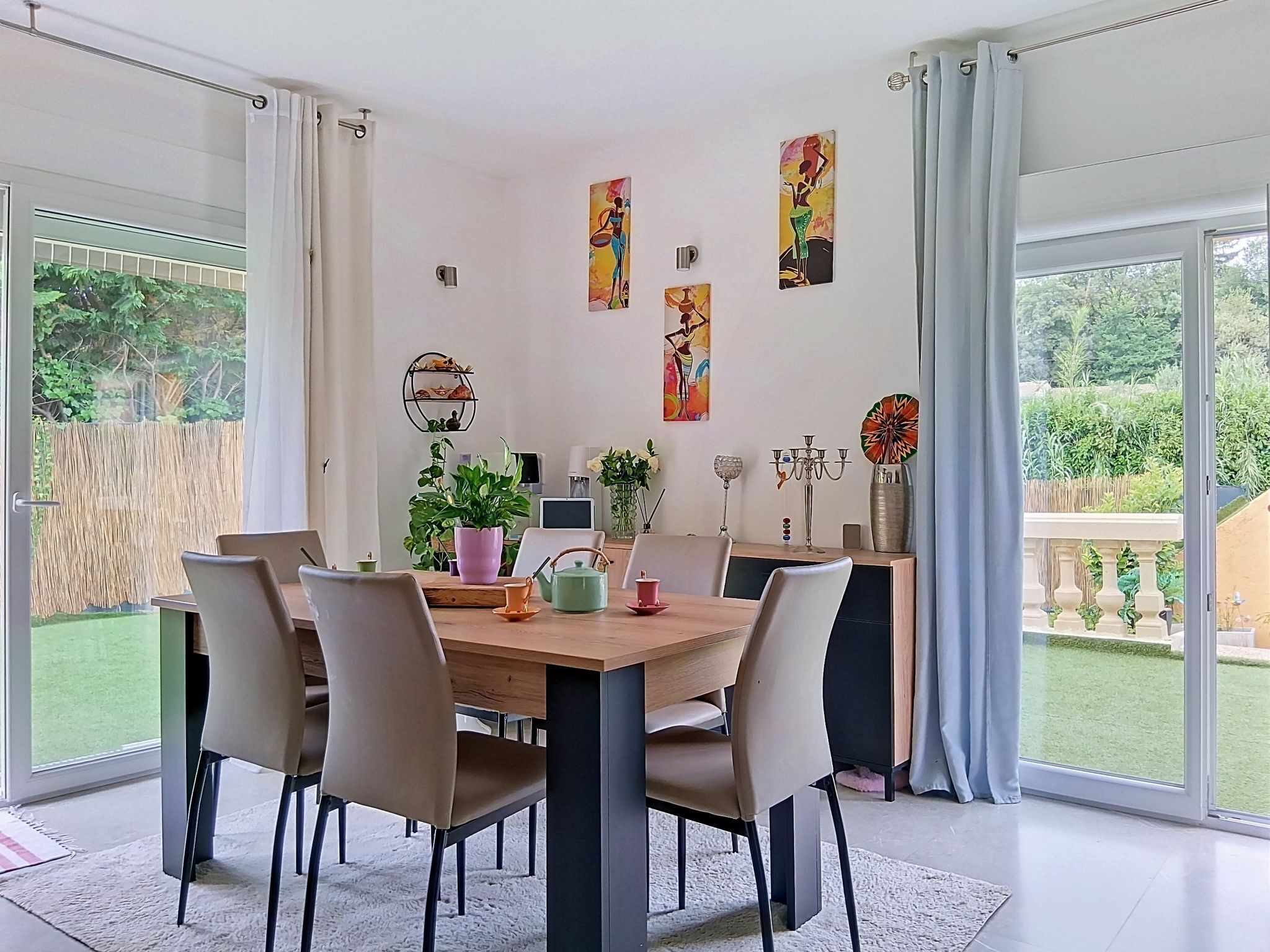A dining area with a wooden table, chairs, and a potted plant.