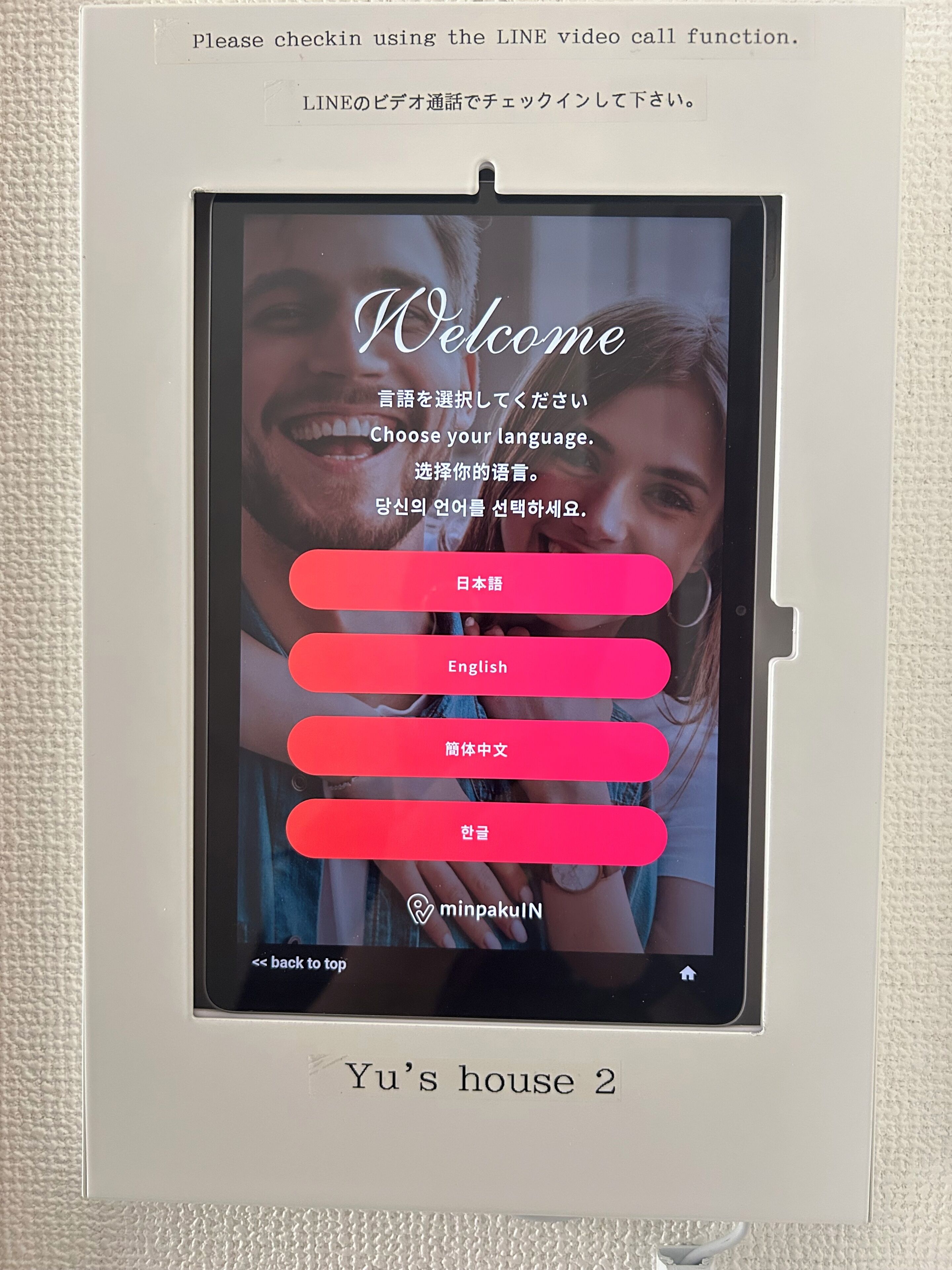 A digital display with a welcome message, language selection options, and a back-to-top button.