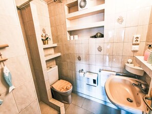 A bathroom with a toilet, sink, and shower area. - Ferienwohnung Seeblick 1 by Interhome (Velden am Wörthersee)