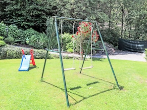 Ein Spielplatz mit Schaukel und Rutsche.
