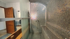 A bathroom with a shower, tiled walls, and a wooden door. - Lovely House in the South (Villeneuve)