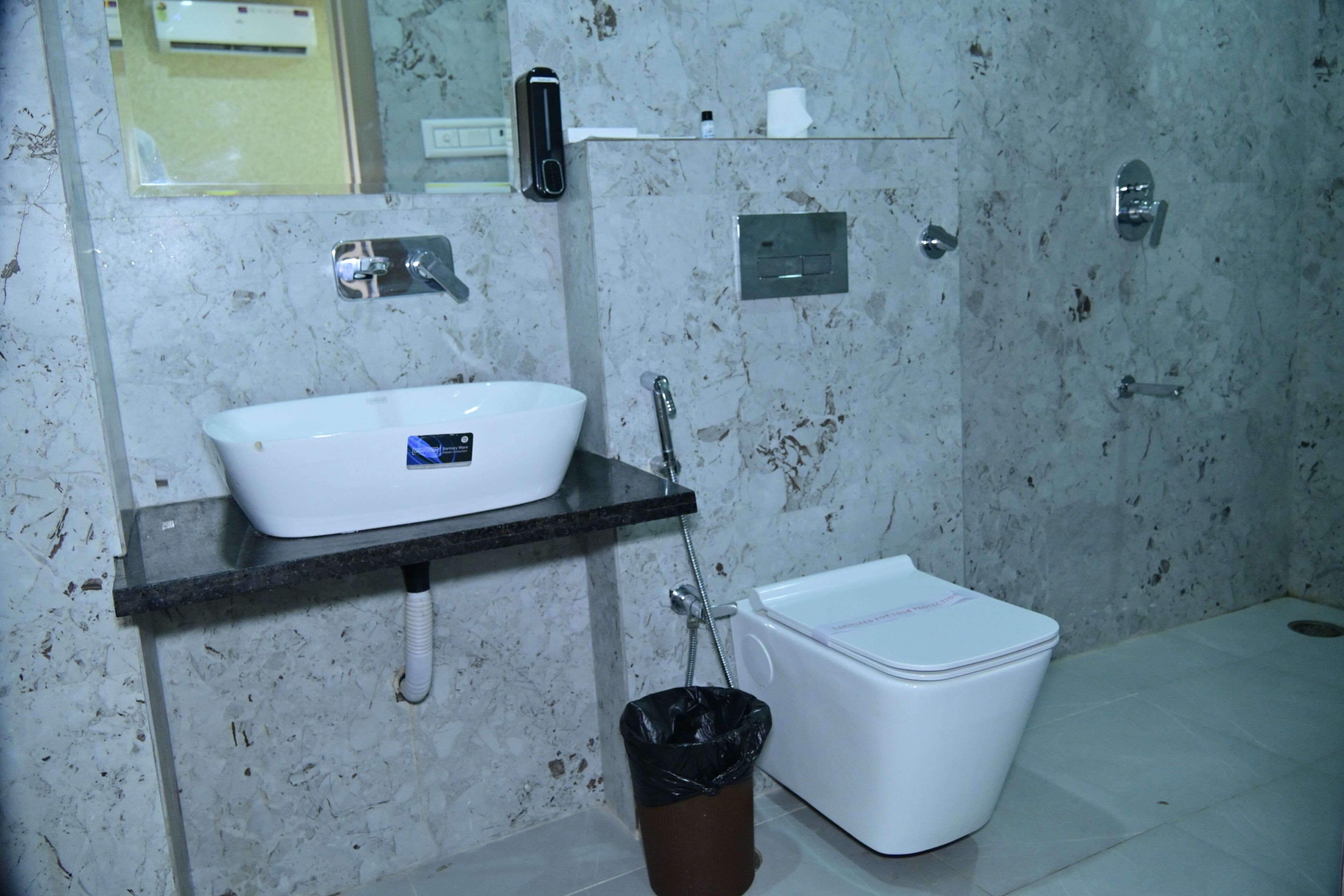 Un bany amb un lavabo blanc, un vàter i un gresol.