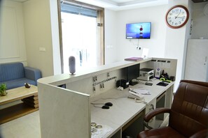 Ein zeitgemäßer Büroraum mit Schreibtisch, Computer und einer Wanduhr.