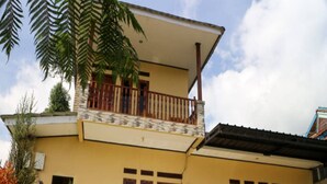 Ein zweistöckiges Gebäude mit Balkon, einer Tür und Fenstern.