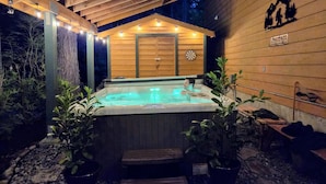 Une cabane en bois dotée d’un bain à remous, de poutres apparentes et d’un jeu de fléchettes.