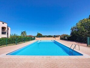 A rectangular swimming pool with a clear blue water surface, surrounded by a tiled deck. - Le Tropique by Interhome (Saint Cyprien)