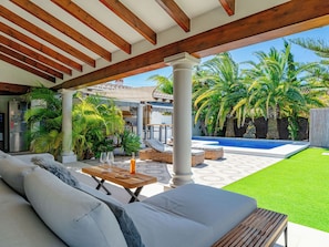 A covered outdoor area with a pool, lounge chairs, and a dining table. - Villa La Calma by Interhome (Jávea)