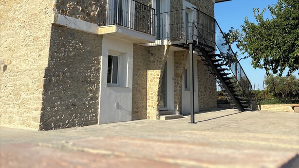 A two-story stone building with a balcony, a staircase, and a door. - Tenuta Ferrante Relais (Abruzzo)