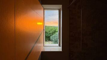 Ein Zimmer mit Fenster, Handtuchhalter und einer Wand mit Struktur.