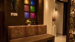 A modern interior with a sofa, a wall with colored panels, a potted plant, and a decorative wall piece.