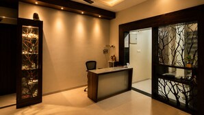 A modern office space with a desk, chair, ceiling fan, and decorative glass panels.