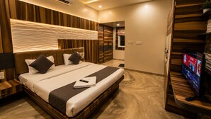 A modern hotel room with a bed, a television, and a ceiling fan.