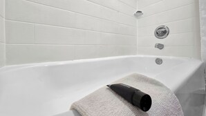 Ein modernes Badezimmer mit weiß gefliesten Wänden und einer Badewanne.