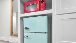 A light blue refrigerator with a digital display and a red microwave above it. - Crystal Palace Resort - Family Suite King (Port Bolivar)