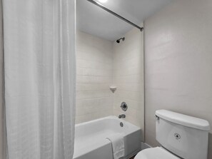 A bathroom with a bathtub, a shower, and a toilet.