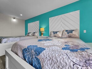 A bedroom with a bed, two nightstands, a lamp, and a mirror.