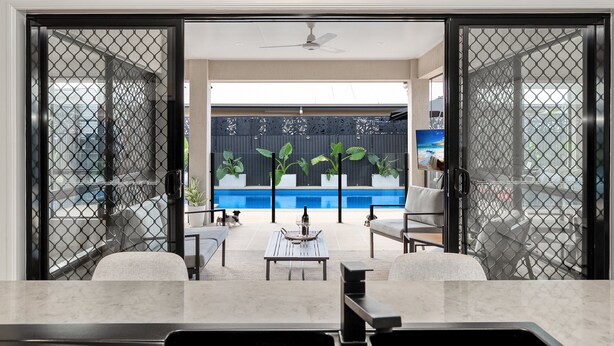 Un espacio habitable abierto con piscina, asientos exteriores y vistas a la ciudad.