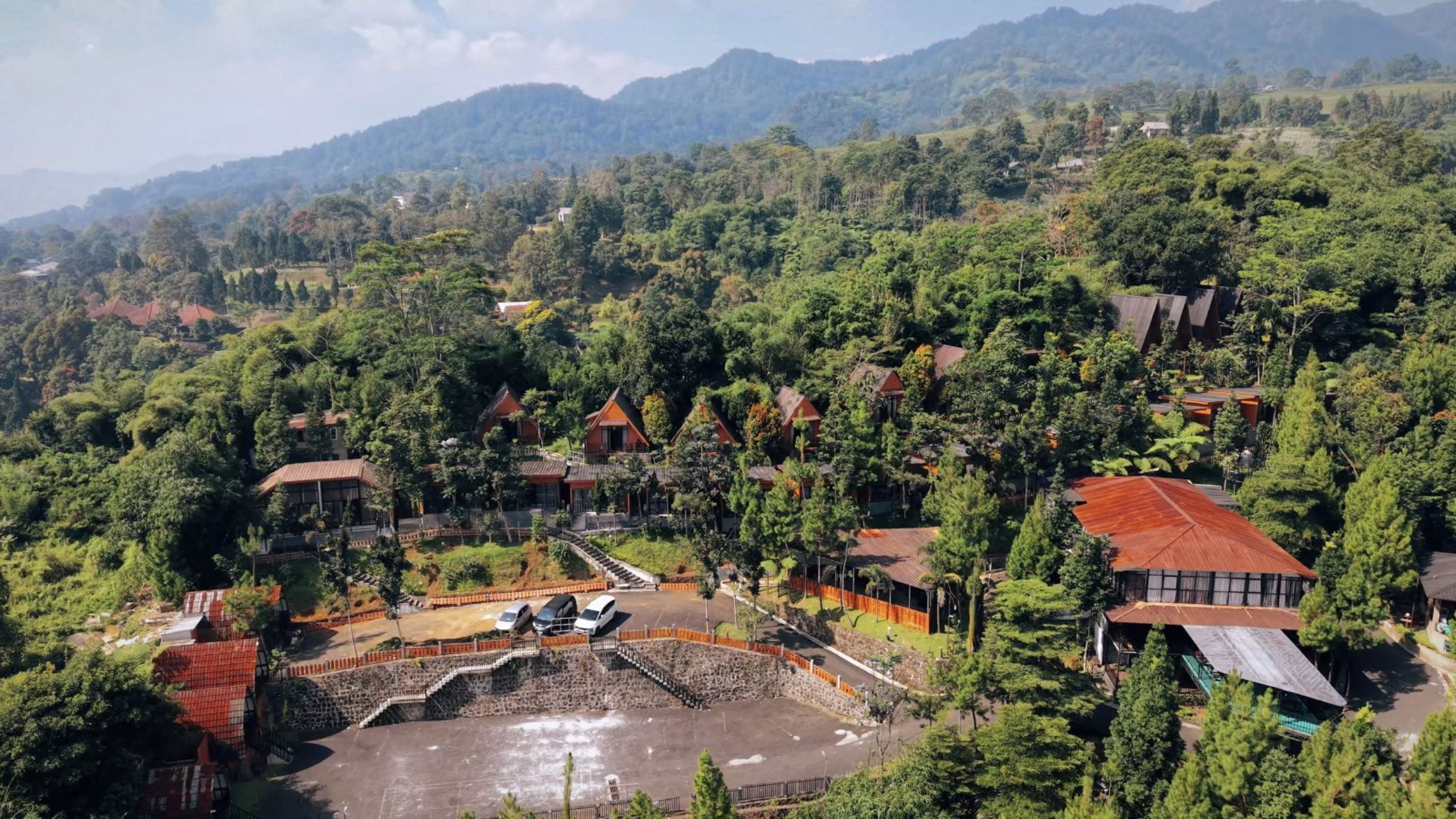A mountainous area with multiple buildings surrounded by dense forest.