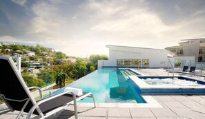 En tagpool med uendeligt kig, liggestole, jacuzzi og udsigt over byen.
