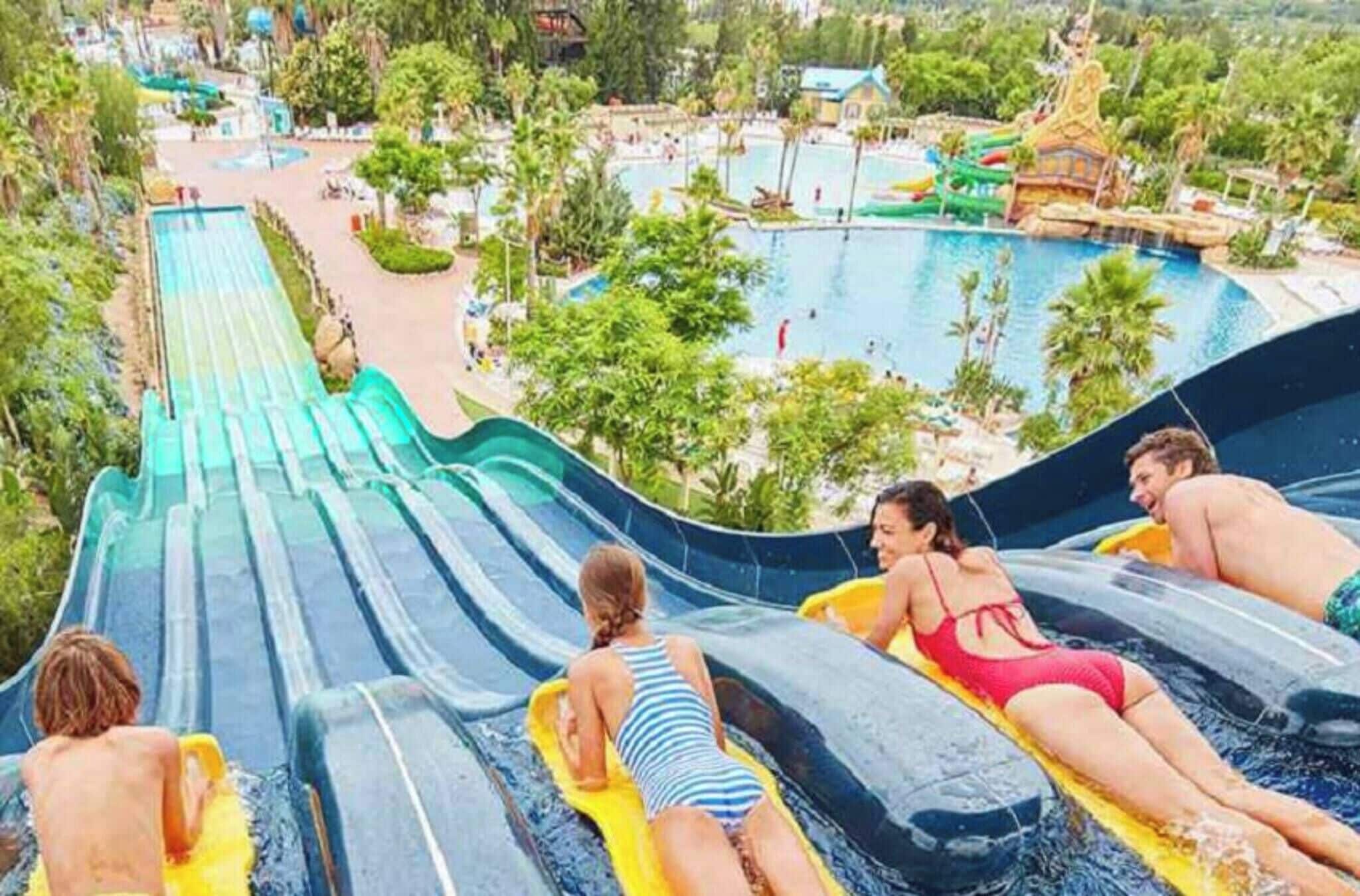 Um parque aquático com um grande tobogã, piscinas e diversas atrações aquáticas.