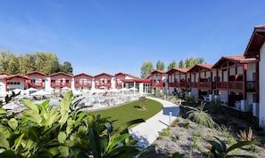 A hotel with multiple red-roofed buildings, a swimming pool, and a well-maintained lawn. - Residence Le Domaine D'uhaina (Urrugne)
