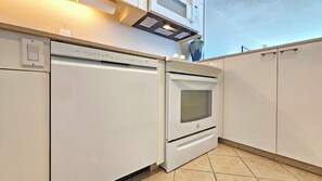 Eine Küche mit eingebautem Geschirrspüler, Backofen und Mikrowelle.
